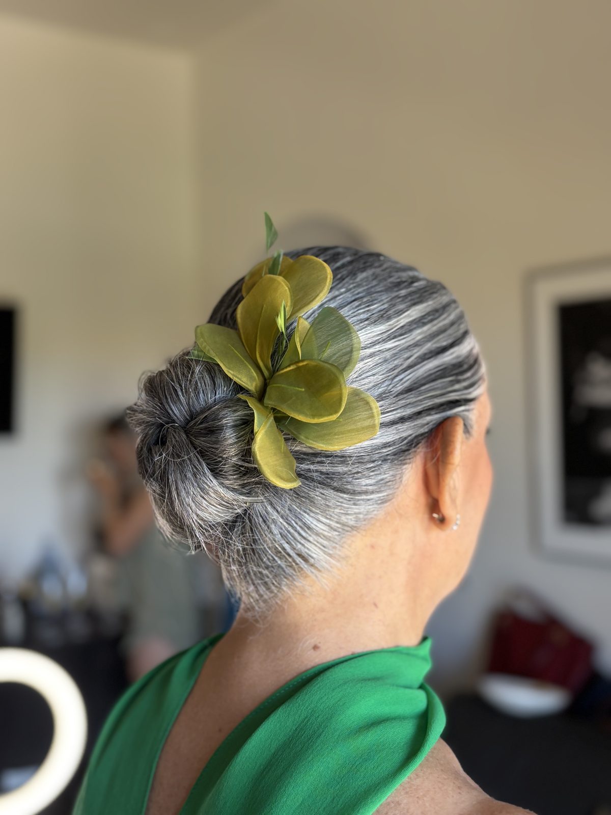 Recogido pulido de invitada con tocado verde