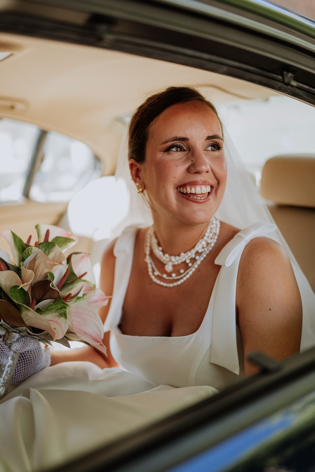 Novia sonriendo en el coche camino de la ceremonia