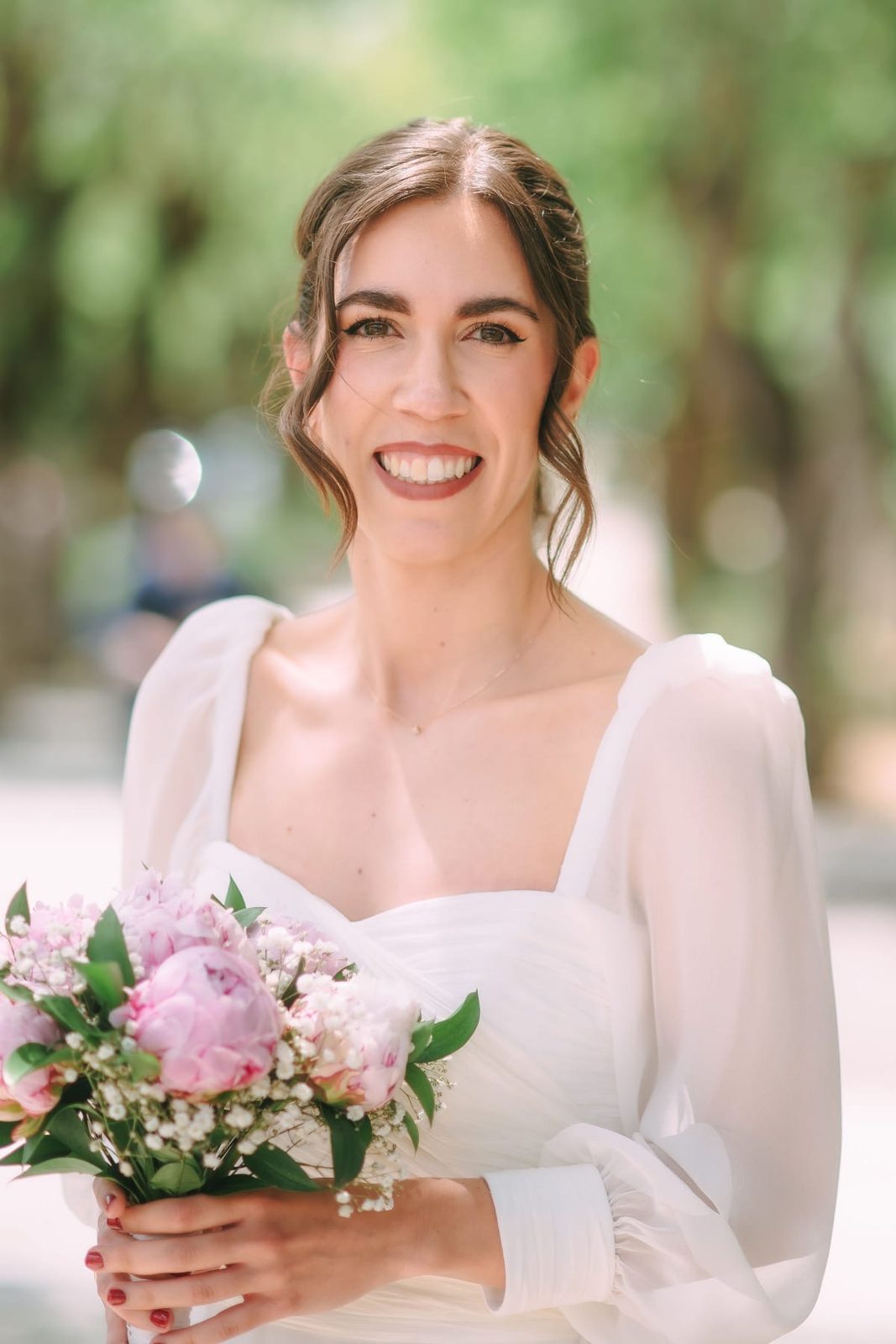 Novia sonriendo con ramo de peonías rosas